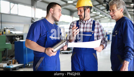 Engineer Teaching Apprentices To Use Computerized cnc metal processing machines Stock Photo