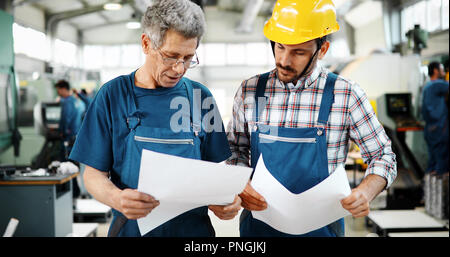 Engineer Teaching Apprentices To Use Computerized cnc metal processing machines Stock Photo