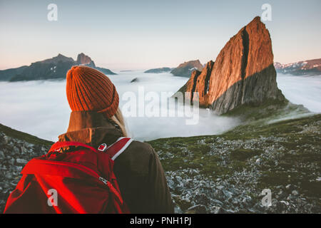 Woman tourist with backpack enjoying view adventure outdoor in Norway active vacations traveling lifestyle sunset Segla mountain Stock Photo