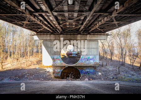 Kiev, Ukraine - March 30, 2014 - Under the Moscovsky bridge in Kiev, Ukraine. The old metal structure is attacked by rust. Grafitti are painted on the Stock Photo