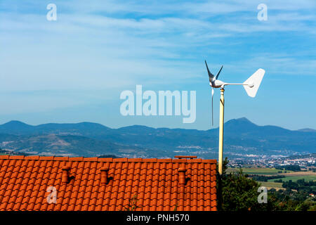 Micro wind turbine on the roof of a house, Puy de Dome department, Auvergne Rhone Alpes, France Stock Photo