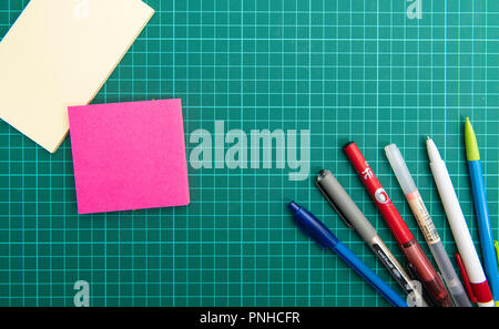 Cutting mat with sticky notes and pens Stock Photo