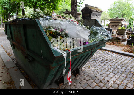 A dumpster filled with discarded flower arrangements that were left behind on graves from visitors at the Père Lachaise Cemetery, Paris, France on a c Stock Photo