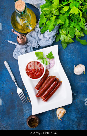 fried sausages with tomato sauce, sausages on plate Stock Photo