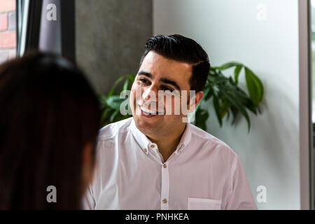 Adult professional smiling indoors. Medium close up. Looking away from camera. Stock Photo