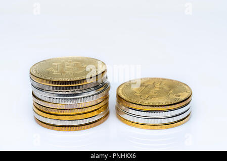 Bitcoins are stacked on a white background. Bitcoin is gold and silver. Stock Photo