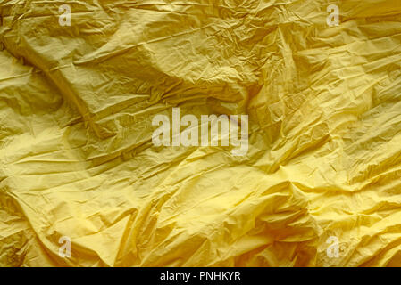 Abstract bright rich yellow background crumpled textile. Top view copy space Stock Photo