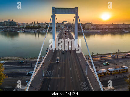 Budapest, Hungary - Beautiful Elisabeth Bridge (Erzsebet hid) at sunrise with golden and blue sky, traditional yellow tram and heavy morning traffic Stock Photo