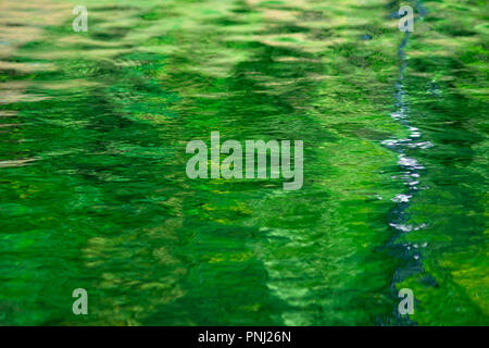Water texture or background. Colorful reflections. Play of light and shadow Stock Photo