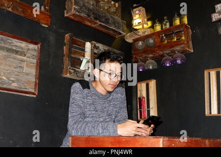 man is playing on his mobile phone in the cafe Stock Photo