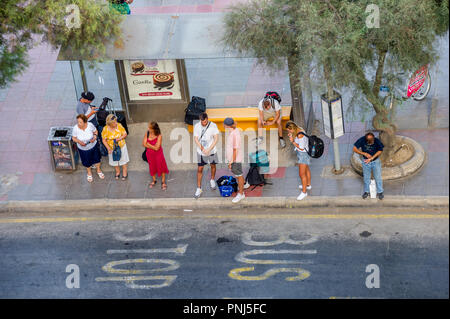 People waiting at a bus stop in Sliema, Malta. Stock Photo