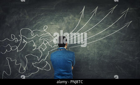 Concept of information processing as a concentrated businessman thinking in front of a huge blackboard as mesh lines come through head and transform i Stock Photo
