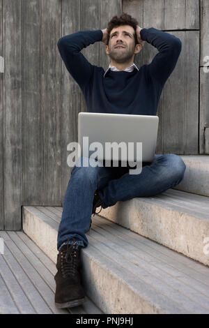 young man with laptop worried with the hands in the head Stock Photo