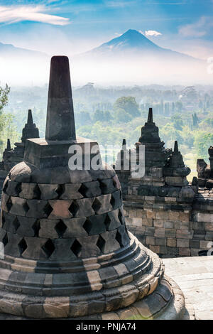 Buddha statue with Mount Merapi in the background, Candi Borobudur buddhist temple, Muntilan, Java, Indonesia Stock Photo