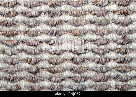 Beige and white synthetic floor carpet covering with wavy geometric pattern, may be used as background or texture