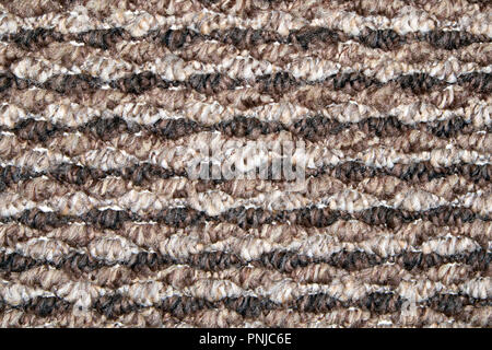 Brown and beige synthetic floor carpet covering with wavy geometric pattern, may be used as background or texture