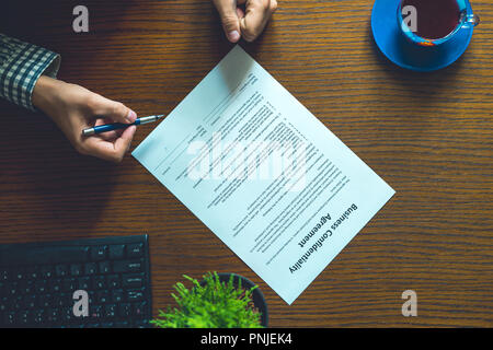 partnership agreement business document signed by a person on the table in office Stock Photo