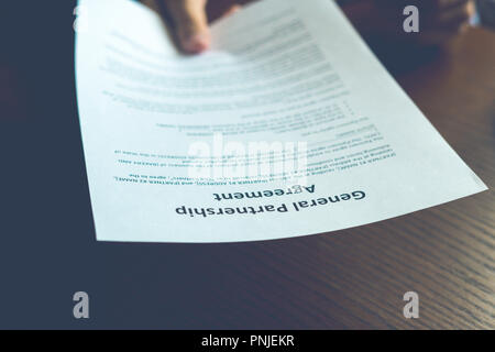 partnership agreement business document signed by a person on the table in office Stock Photo