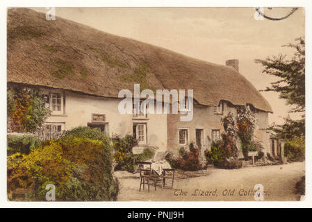 Charming original tinted colour postcard of pretty picture postcard old thatched cottages, vernacular architecture, at Church Cove, The Lizard, Cornwall, U.K. dated 1913 Stock Photo