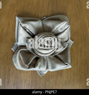 golden napkin origami rose table decoration for party events and holidays. wooden table background Stock Photo