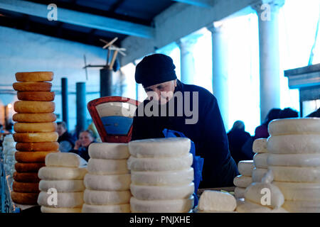 A vendor sells wheels of Sulguni brined cheese at the market in the town of Zugdidi the capital of the Samegrelo Zemo Svaneti region in the Republic of Georgia Stock Photo