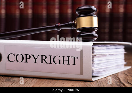 Wooden Judge Gavel On Copyright Law Folder With Paper Over Wooden Table Stock Photo