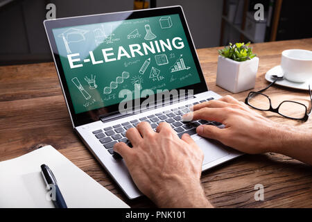 Man's Hand Using Laptop Showing E-learning Concept On Screen Stock Photo
