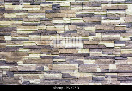 Wall of bricks of different shades of brown close up Stock Photo
