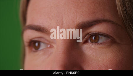 Extreme close up of Caucasian woman's eyes on green screen Stock Photo