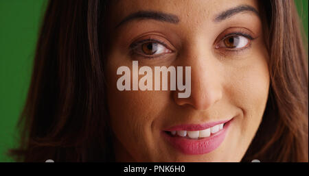 Close up of beautiful Latina female smiling at camera on green screen Stock Photo