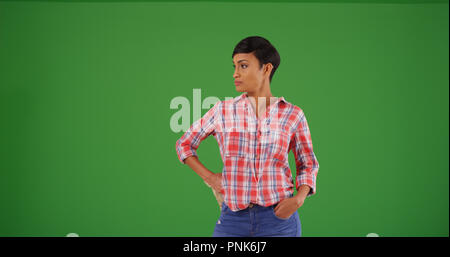 Black female gardener with gardening gloves wearing flannel on green screen Stock Photo