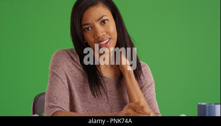 Young black woman with neck pain rubbing neck on green screen Stock Photo
