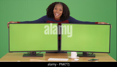 Black woman posing with computers with green screen displays on green screen Stock Photo