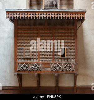 Mamluk era style oriel window covered by interleaved wooden grid (Mashrabiya) on stone wall, Facade of the House of Egyptian Architecture Stock Photo