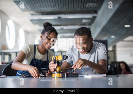 High school students working on a robotic arm in class Stock Photo