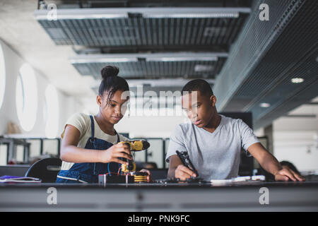 High school students working on a robotic arm in class Stock Photo
