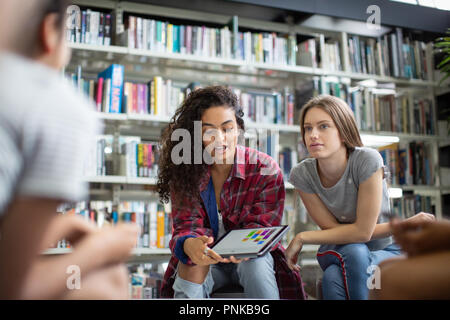 High school students studying together in a library with a digital tablet Stock Photo