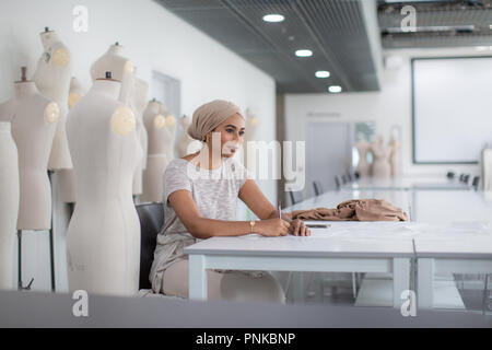 Muslim female fashion designer working on ideas Stock Photo