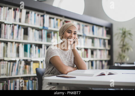 Happy muslim female student in college library Stock Photo
