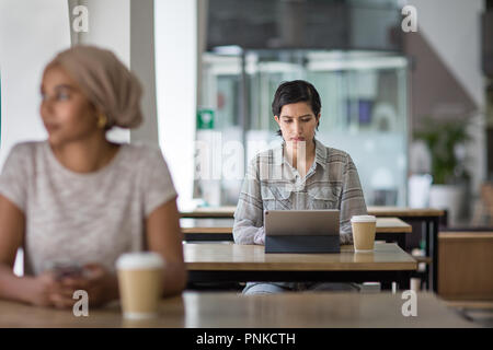 Arabic businesswoman using a digital tablet in a cafe Stock Photo