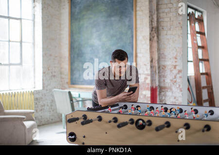 Young adult male using smartphone in a creative office Stock Photo