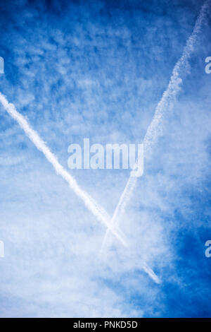 Jet contrails against unusual cloud formations in central Colorado, USA Stock Photo