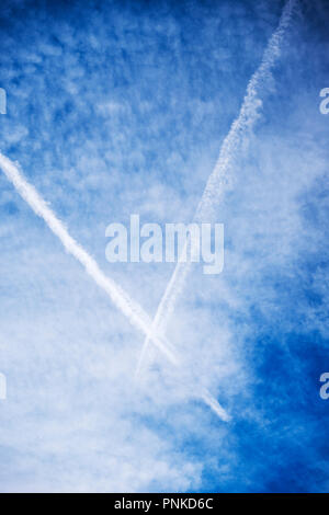 Jet contrails against unusual cloud formations in central Colorado, USA Stock Photo