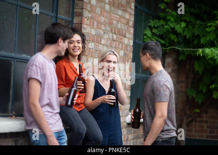 Millennials drinking beer in pub garden Stock Photo
