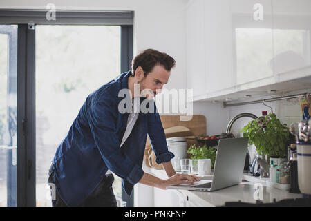 Adult male working from home in kitchen Stock Photo