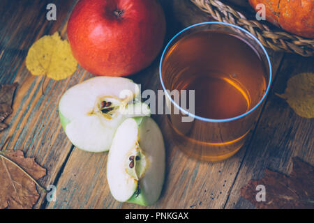 Cold apple cider or apple juice with fresh apples on a wooden background. Autumn drinks. Autumn mood Stock Photo