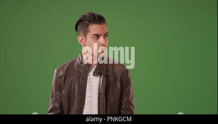 Millennial Latino man in leather jacket on green screen Stock Photo
