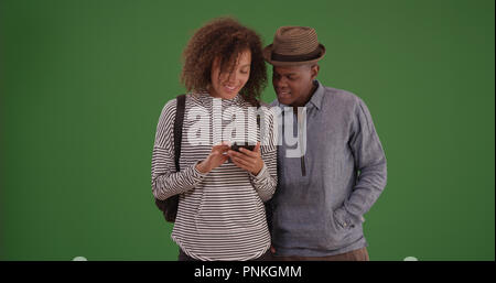 African American millennial couple using phone on green screen Stock Photo