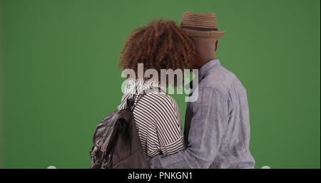 Black couple embracing and staring off into distance on green screen Stock Photo