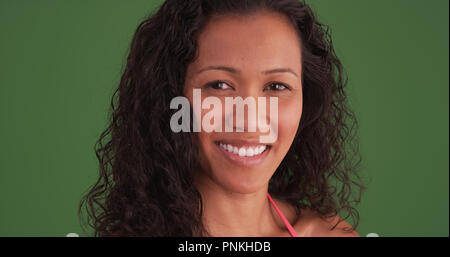 Closeup of mixed race woman smiling at camera on green screen Stock Photo
